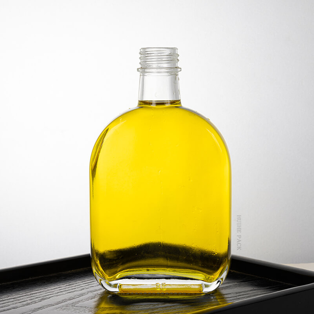 Bottiglia di liquore in vetro trasparente piatto ovale con tappo a vite