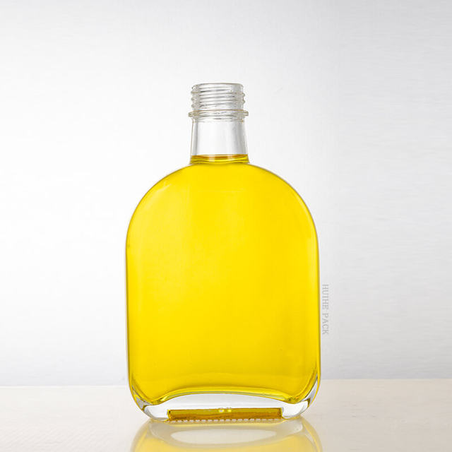 Bottiglia di liquore in vetro trasparente piatto ovale con tappo a vite