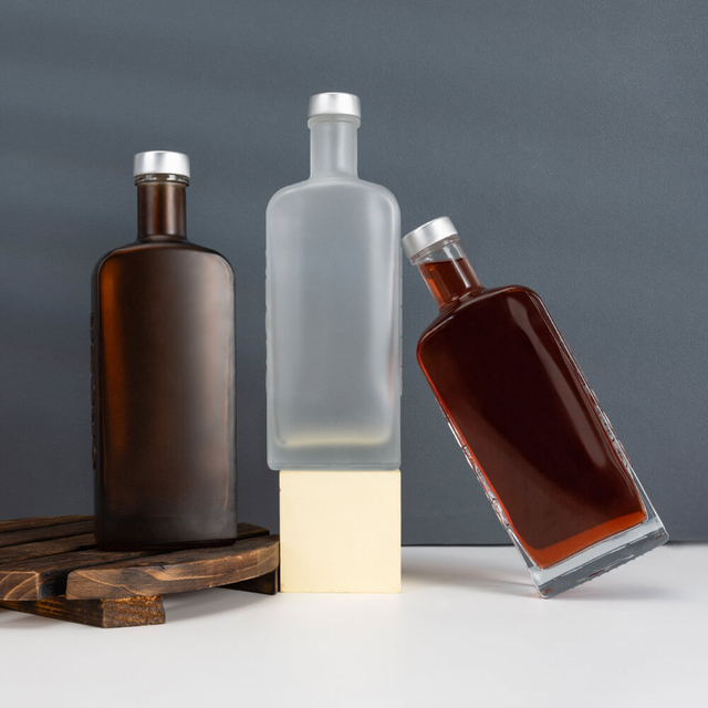 Bottiglie di alcol vetrosa rettangolare piatta.